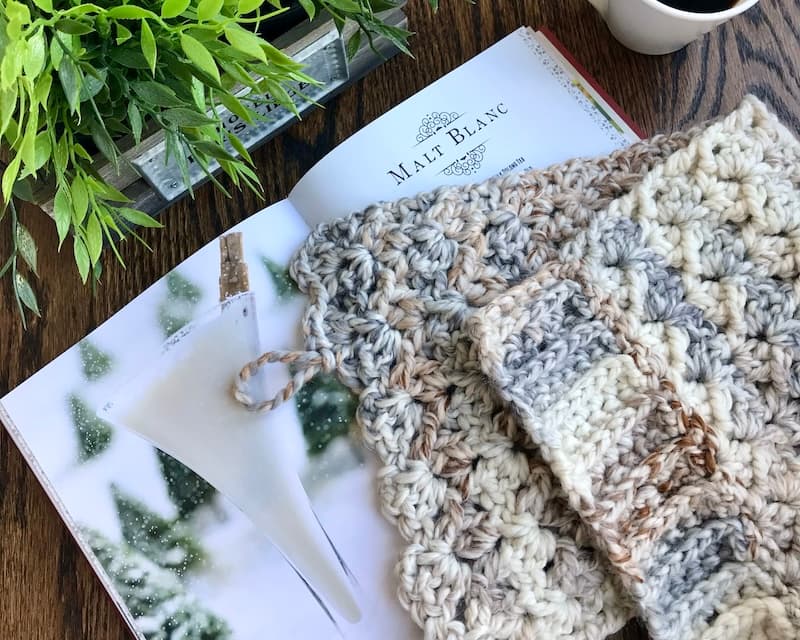 partly crocheted neutral cowl laying on top of book of cocktails