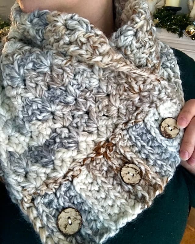 close up of crochet cowl in thick and quick fossil with 3 wooden buttons