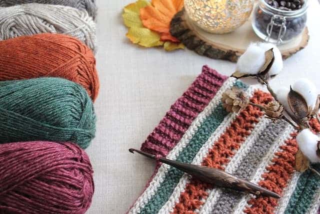 crochet striped cowl in autumn colours with cafe streamline ergonomic crochet hook and skeins of Lion Brand Heartland to the side