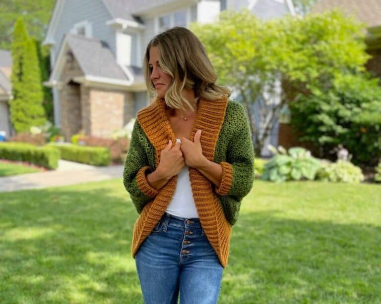 Blond woman wearing green and gold textured crochet shrug with oversized ribbed collar