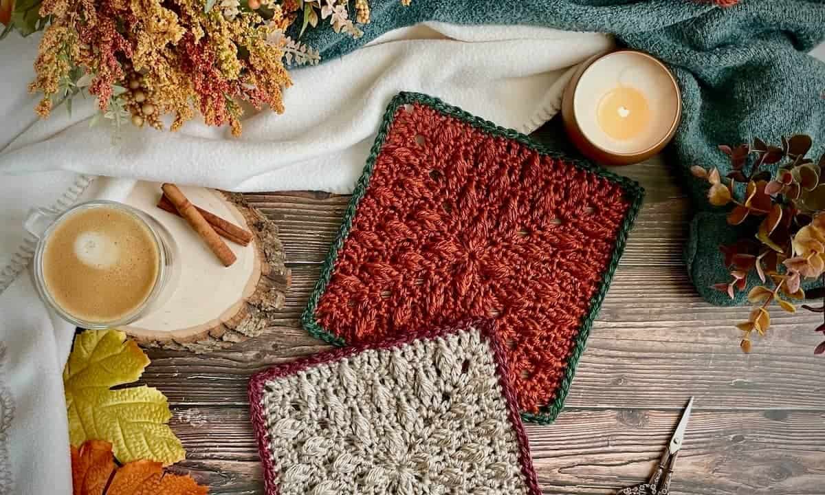 Orange textured crochet leaf blanket square with green border and Fall leaves, with another crochet blanket square in grey and orange placed partially on top