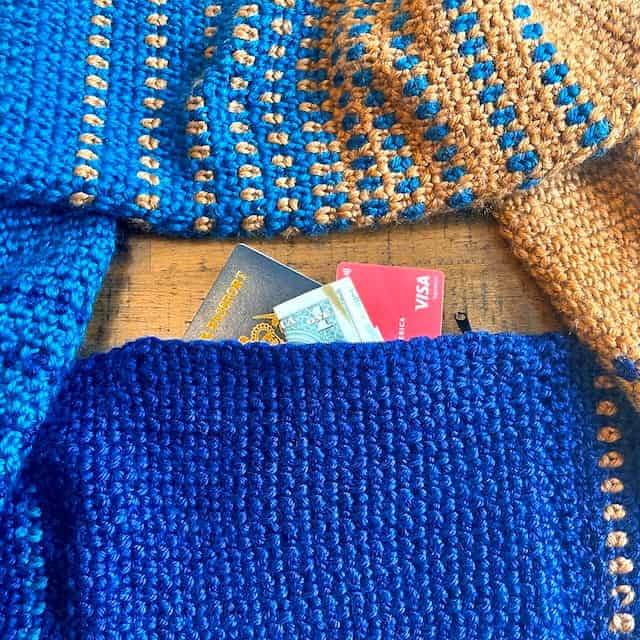 crochet infinity scarf in blue and gold with hidden pocket containing Credit Card, dollar bills and a passport