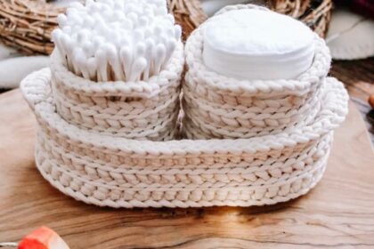 cream crochet nesting pots with two round pots containing cotton pads and q-tips, nestled inside a larger oval nesting basket