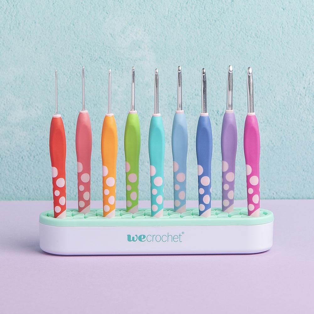 Set of We Crochet Dot Hooks in vibrant hues, standing in the matching caddy